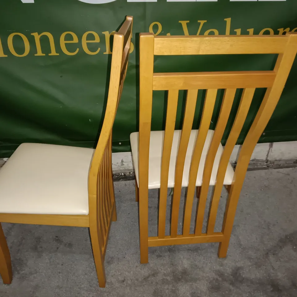 PAIR OF WOODEN SLAT BACK DINING CHAIRS WITH CREAM FAUX LEATHER SEAT PADS 