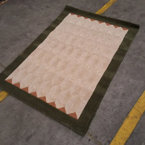 RECTANGULAR RUG WITH BEIGE CENTRE, DARK GREEN BORDER AND ORANGE CHEVRON CORNER DETAILING APPROXIMATELY 120Γ170CM