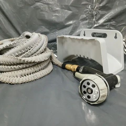 Garden hose kit with coiled hose, spray nozzle and wall-mount bracket