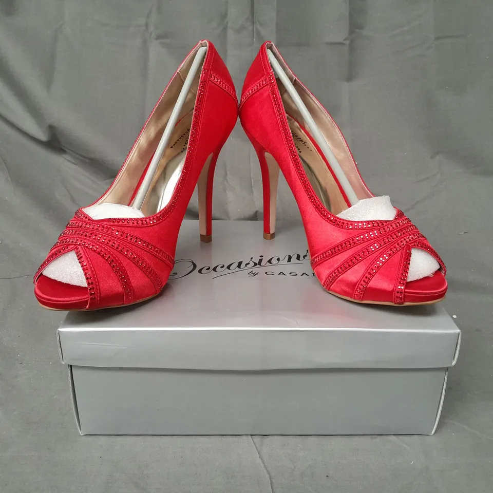 BOX OF APPROXIMATELY 10 BOXED PAIRS OF OCCASIONS BY CASANDRA PEEP TOE HIGH HEEL SHOES IN RED SATIN W. JEWEL EFFECT - VARIOUS SIZES