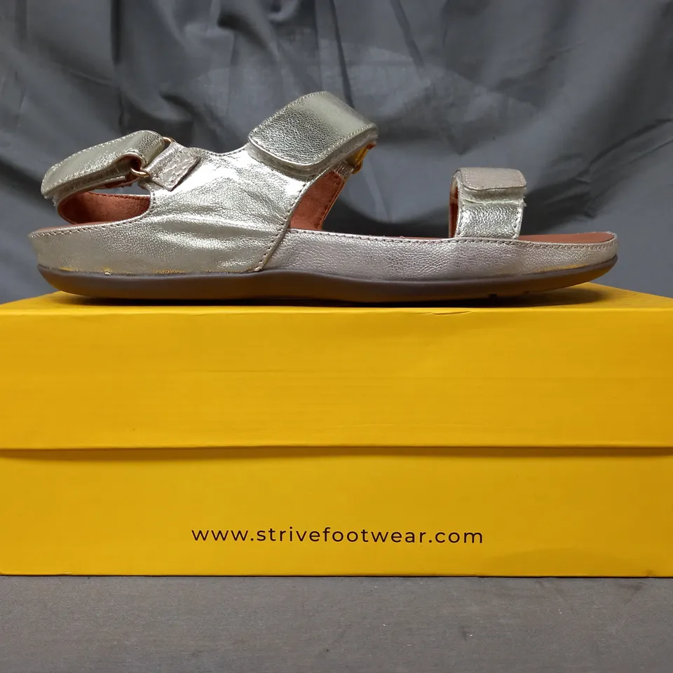 BOXED PAIR OF STRIVE SANDALS IN METALLIC GOLD SIZE 5