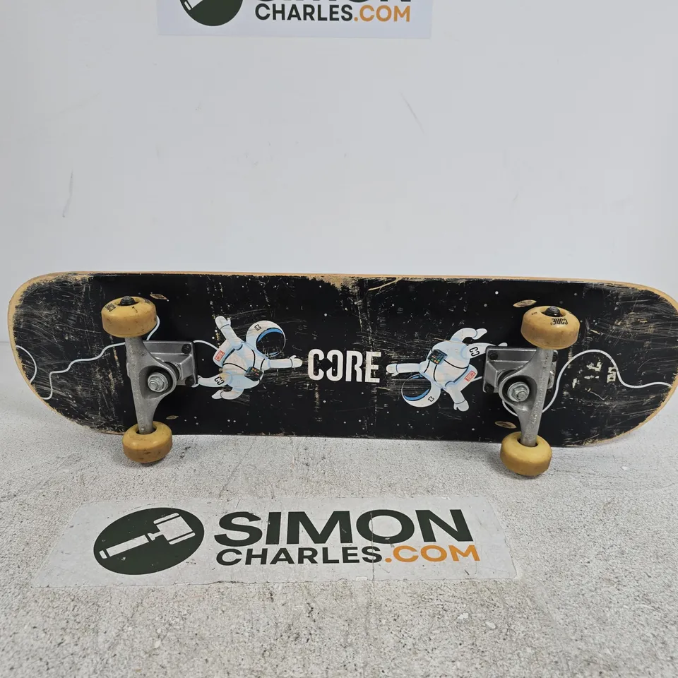 CORE SKATEBOARD – BLACK DECK WITH ASTRONAUT ARTWORK AND CORE BRANDING, YELLOW WHEELS