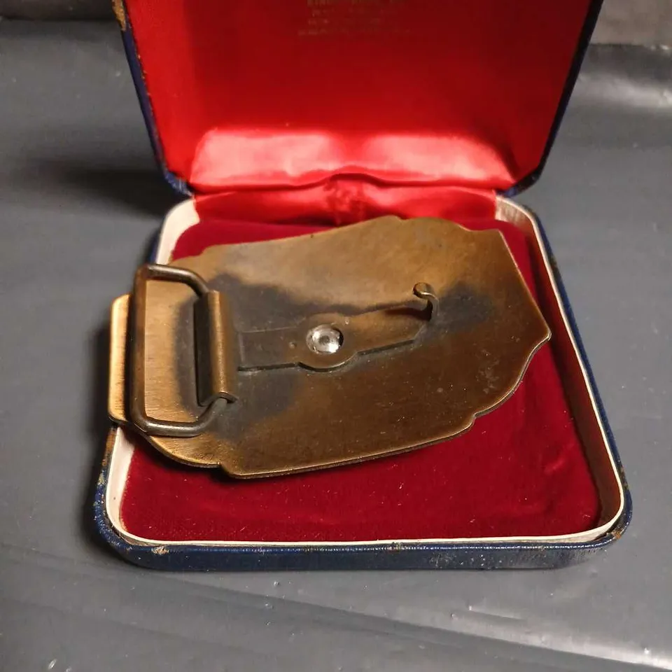 BRASS BELT BUCKLE WITH HORSE & RIDER MOTIF – FLORAL ENGRAVING IN BRAVINGTONS CASE 