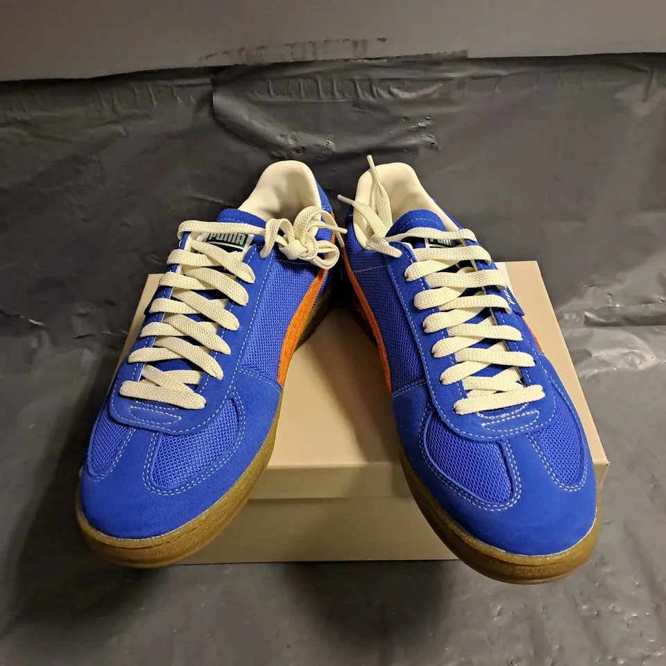 BOXED PAIR OF PUMA SUPER TEAM HANDY TRAINERS IN ULTRA BLUE/RICKIE ORANGE SIZE 7