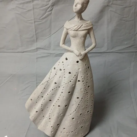 Ceramic sculpture of standing woman in a dotted gown