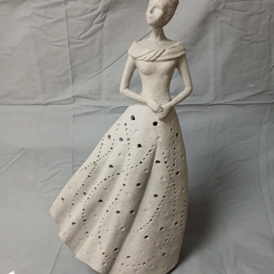 Ceramic sculpture of standing woman in a dotted gown