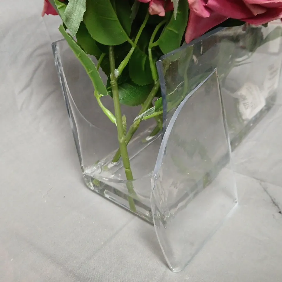 Artificial pink rose arrangement in clear glass vase