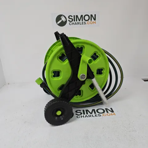 GREEN GARDEN HOSE REEL ON WHEELED TROLLEY WITH COILED HOSE