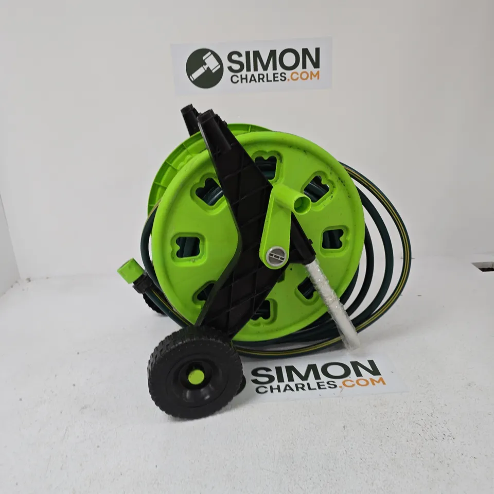 GREEN GARDEN HOSE REEL ON WHEELED TROLLEY WITH COILED HOSE