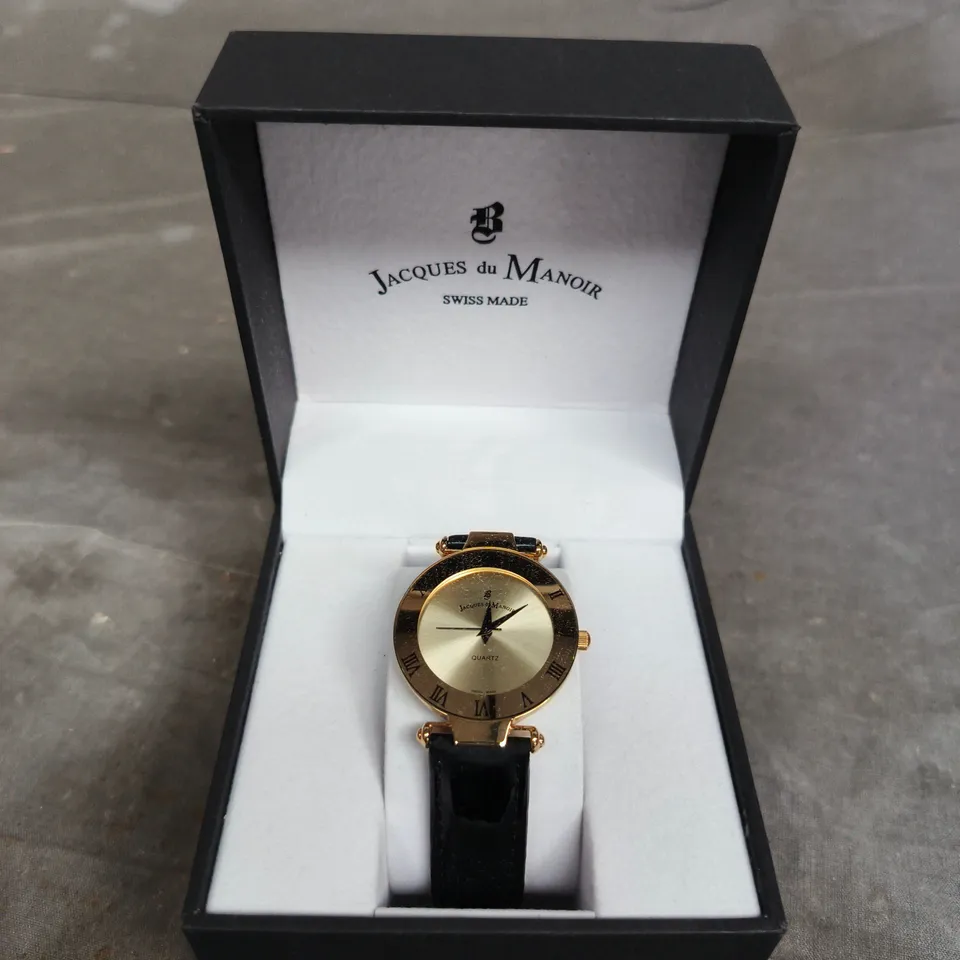 JACQUES DU MANOIR SWISS MADE QUARTZ WRISTWATCH – GOLD-TONE CASE, BLACK LEATHER STRAP