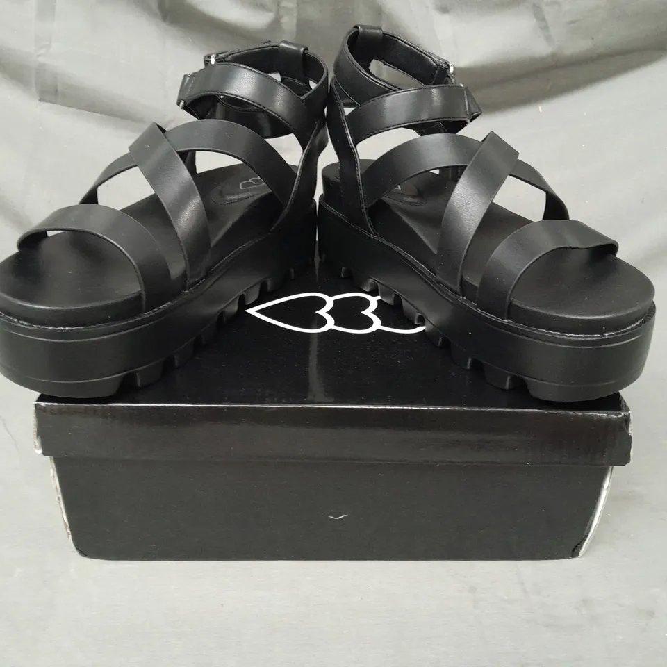 BOXED PAIR OF DESIGNER CROSS STRAP CHUNKY FLAT SANDALS IN BLACK SIZE 7