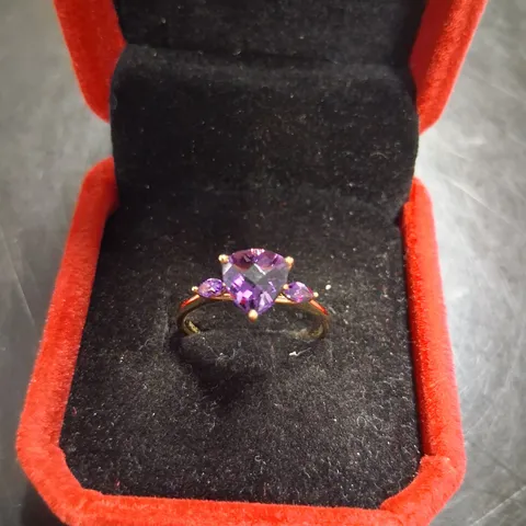 9CT YELLOW GOLD RING SET WITH A TRILLIANT CUT AND A MARQUISE CUT AMETHYST TO EACH SHOULDER