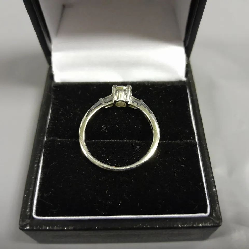 18CT WHITE GOLD RING SET WITH A NATURAL DIAMOND TO THE CENTRE AND A BAGUETTE TO EACH SHOULDER