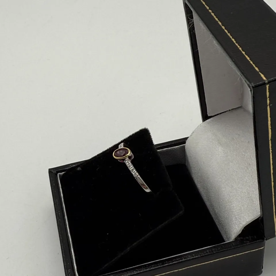 18CT GOLD RING SET WITH AN OVAL CUT RUBY AND NATURAL DIAMONDS