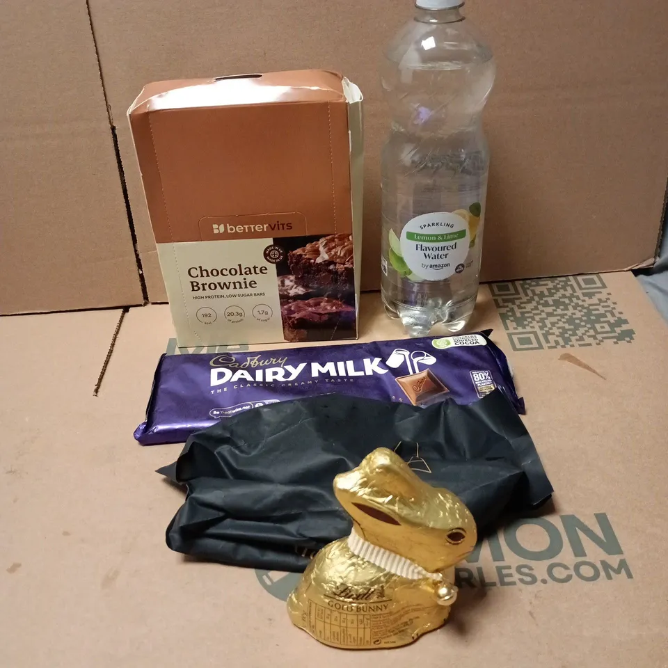 TOTE OF APPROXIMATELY 20 ASSORTED FOOD/DRINK ITEMS TO INCLUDE BETTERVITS CHOCOLATE BROWNIES, AMAZON SPARKLING LEMON AND LIME WATER, CADBURY DAIRY MILK, ANCIENT + BRAVE, LINDT GOLD BUNNY ETC