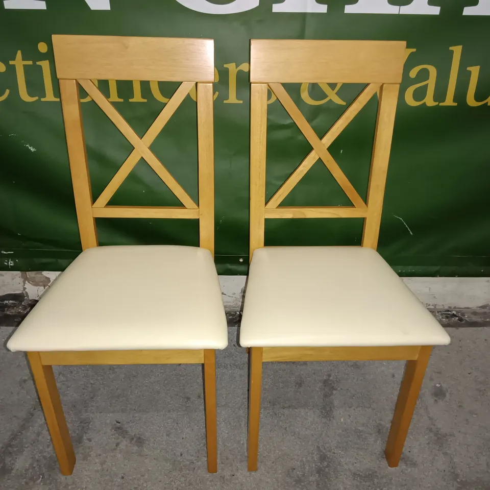 PAIR OF WOODEN CROSS BACK DINING CHAIRS WITH CREAM FAUX LEATHER SEAT PADS