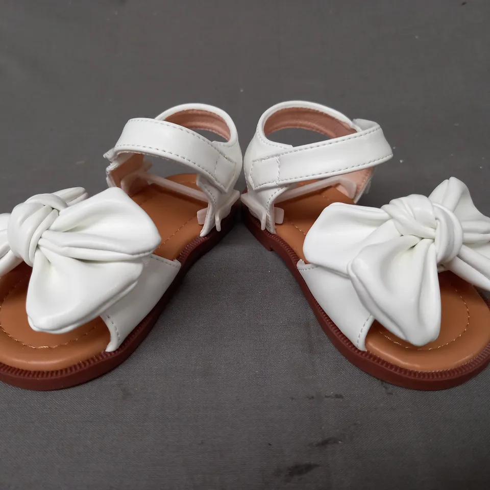 BOXED PAIR OF DESIGNER INFANT OPEN TOE SANDALS IN WHITE W. BOW DETAIL EU SIZE 20