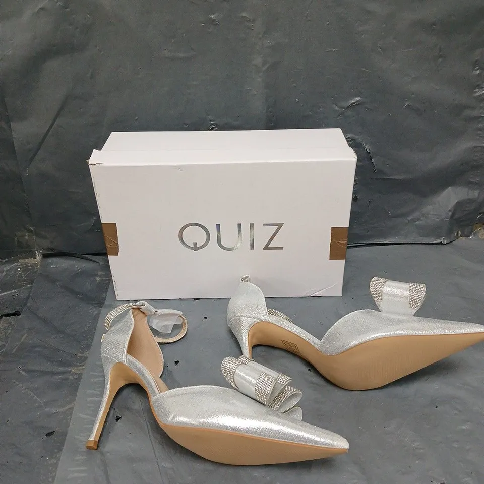 BOXED PAIR OF QUIZ BOW HIGH JEWELLED SILVER HEELS - SIZE 6 