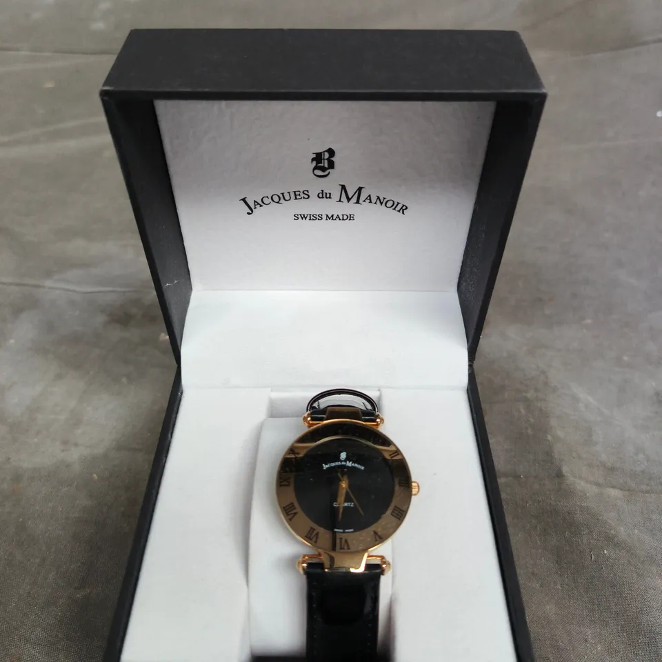 JACQUES DU MANOIR SWISS MADE QUARTZ WATCH – BLACK DIAL, GOLD-TONE CASE, LEATHER STRAP