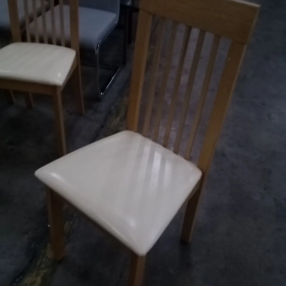 APPROXIMATELY 4 OAK EFFECT SLATTED BACK DINING CHAIRS WITH CREAM FAUX LEATHER SEAT PADS 