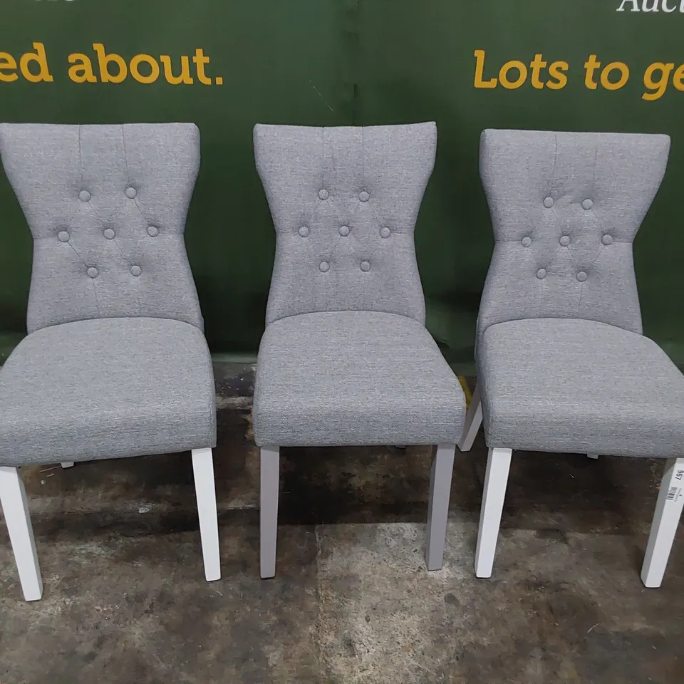 THREE UPHOLSTERED BUTTONED BACK DINING CHAIRS GREY FABRIC ( ODD LEG COLOUR)