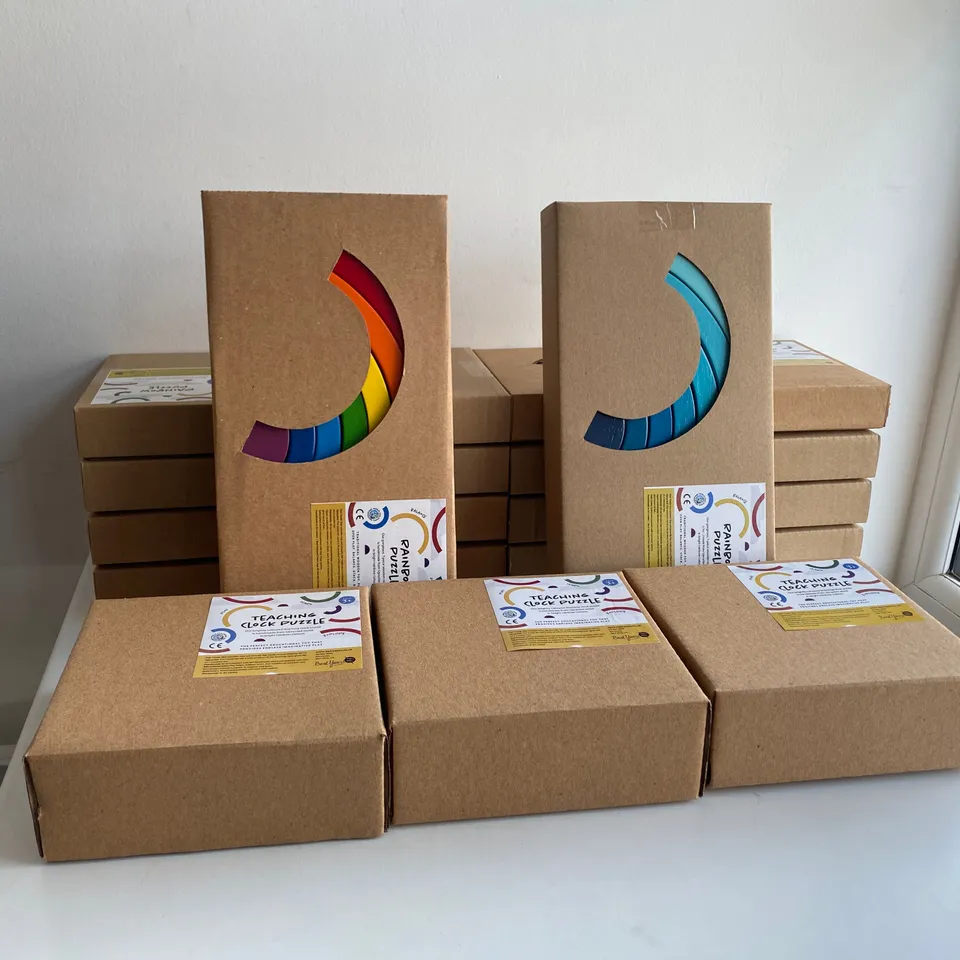 BOX OF 13 BRAND NEW ITEMS TO INCLUDE: 10 X RAINBOW PUZZLE, 3 X TEACHING CLOCK PUZZLE