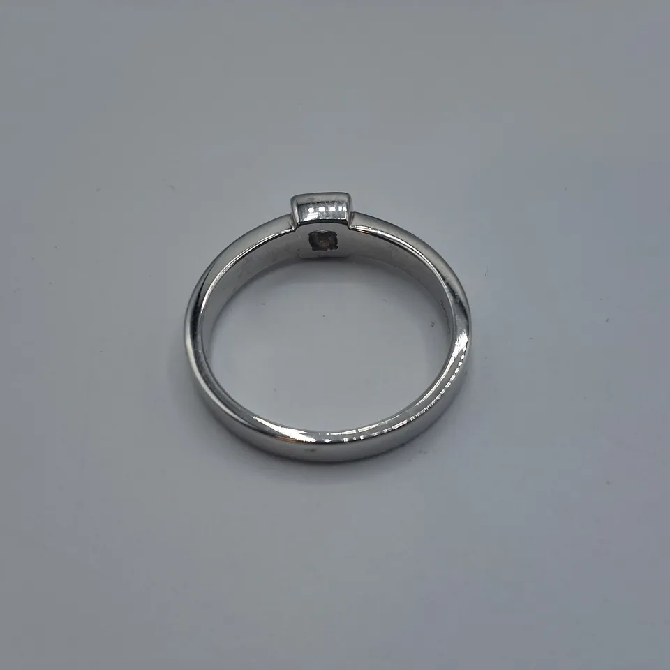 18CT WHITE GOLD SOLITAIRE RING SET WITH A NATURAL RUB OVER DIAMOND