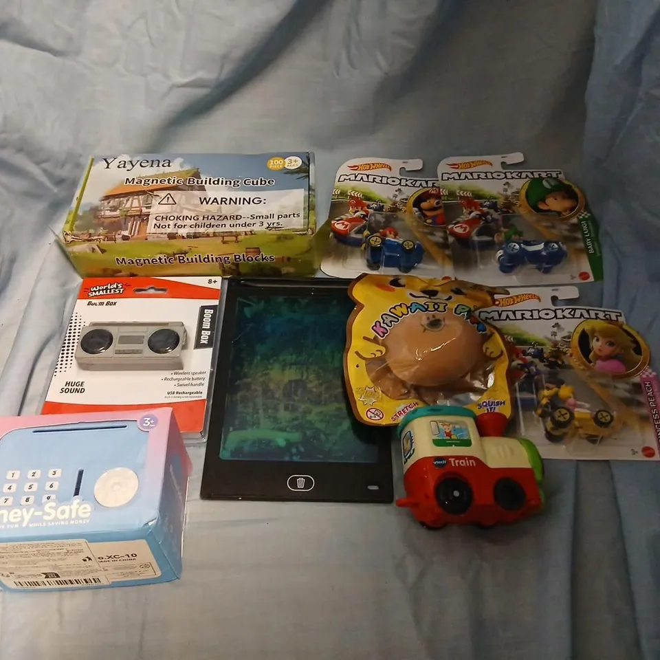 LARGE QUANTITY OF ASSORTED TOYS AND ACCESSORIES TO INCLUDE; WORLD'S SMALLEST BOOMBOX, YAYENA MAGNETIC BUILDING CUBE, HOT WHEELS MARIO KART, VTECH TRAIN, LCD DRAWING TABLET AND MONEY-SAFE