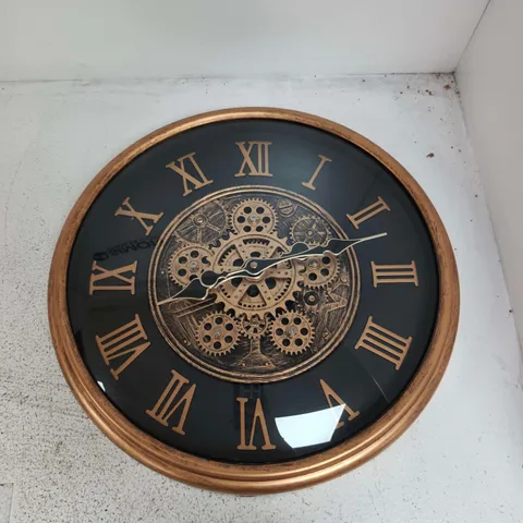 ROUND WALL CLOCK WITH GEAR MOTIF IN BRONZE FINISH AND ROMAN NUMERALS