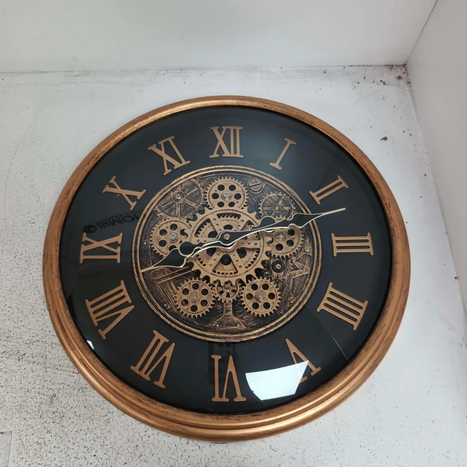 ROUND WALL CLOCK WITH GEAR MOTIF IN BRONZE FINISH AND ROMAN NUMERALS