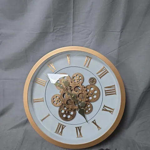 ROUND GOLD-TONE WALL CLOCK WITH EXPOSED GEAR MECHANISM AND ROMAN NUMERALS