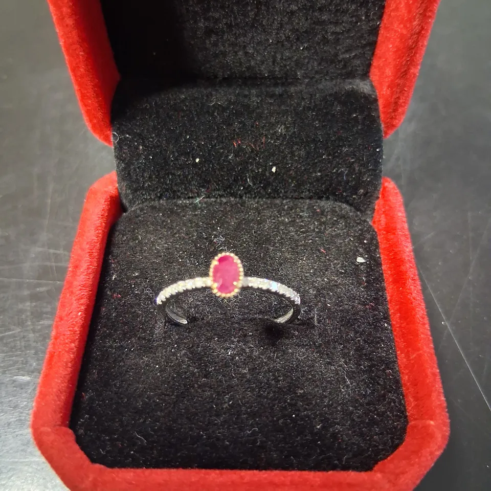 18CT GOLD RING SET WITH AN OVAL CUT RUBY AND NATURAL DIAMONDS TO THE SHOULDERS 