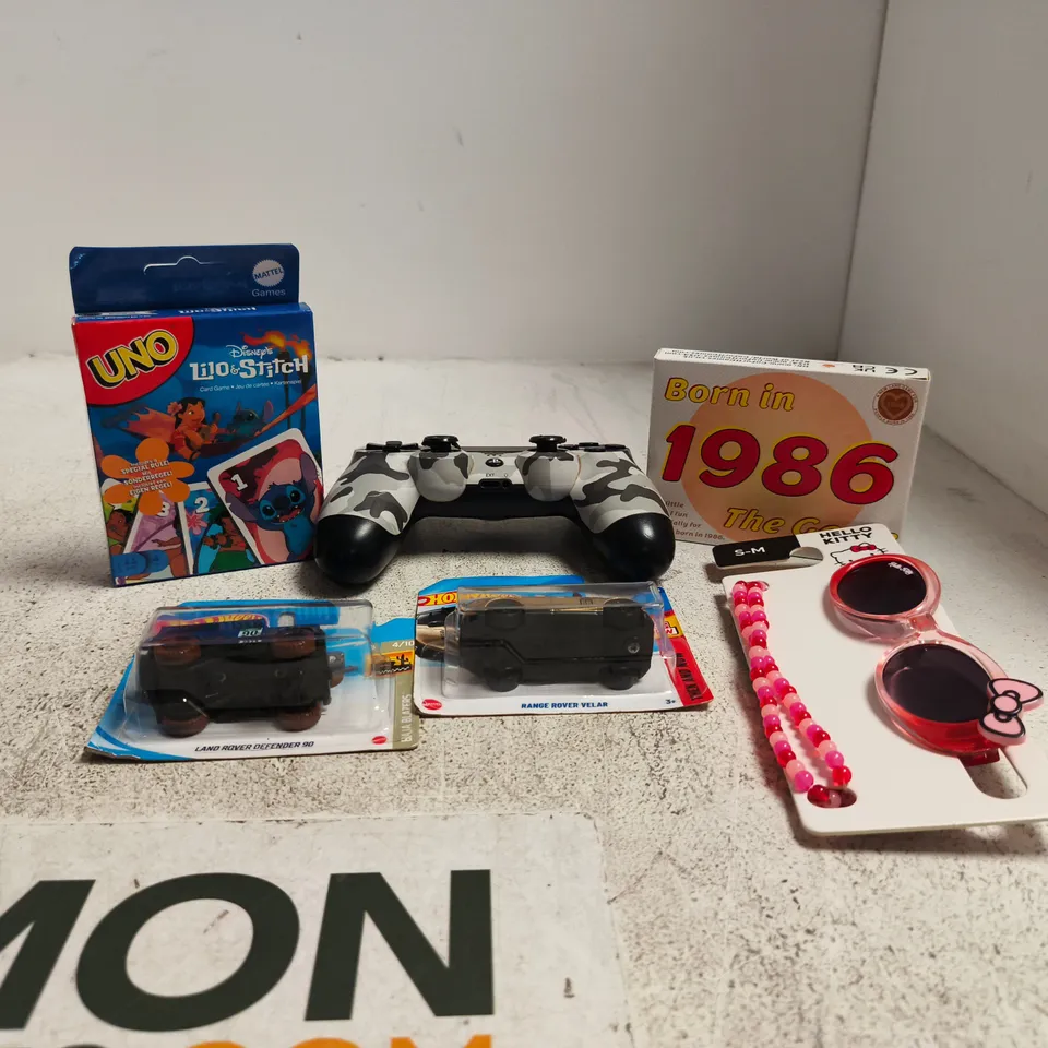 TOTE OF APPROXIMATELY 22 ASSORTED TOY/GAME ITEMS TO INCLUDE PLAYSTATION CONTROLLER, UNO LILY AND STITCH DISNEY, HOT WHEELS CARS, HELLO KITTY SUNGLASSES ETC