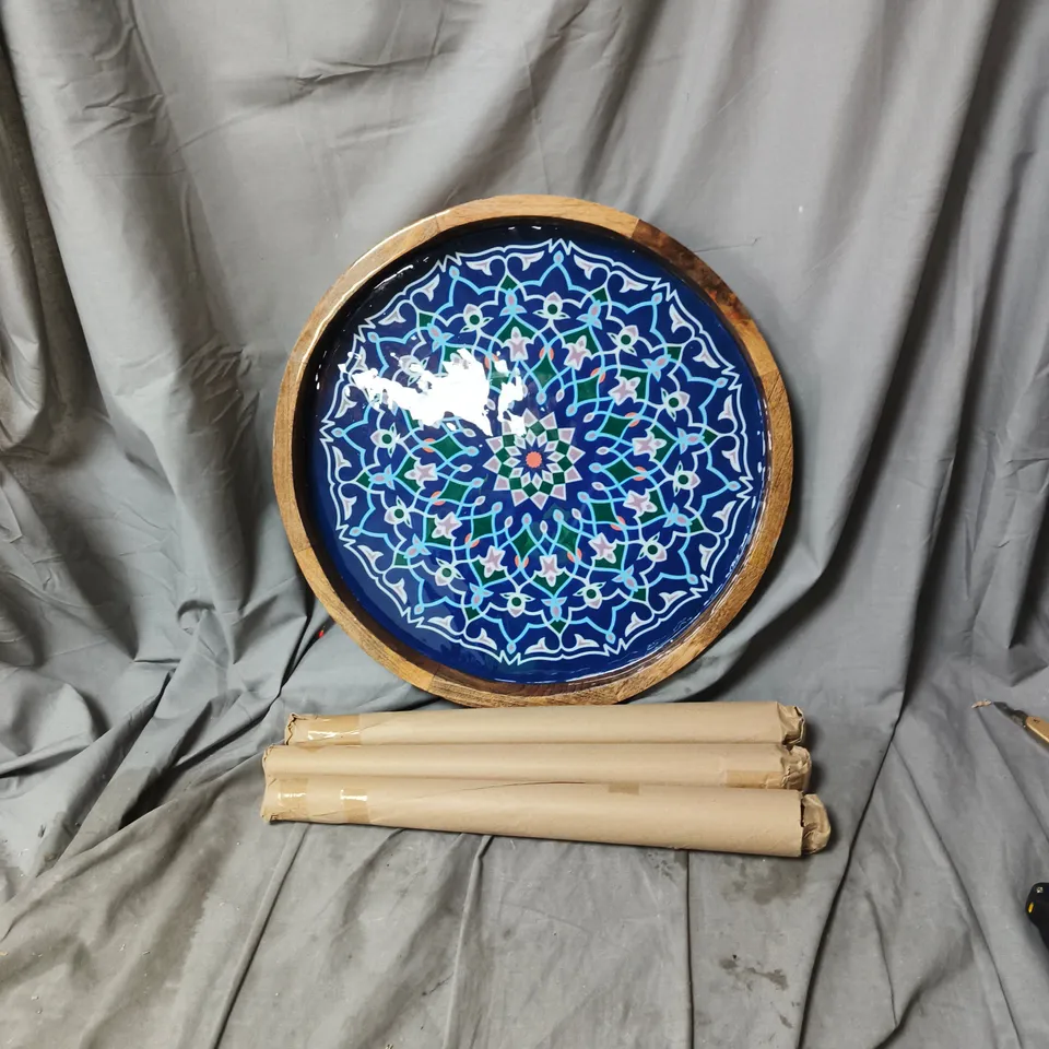 Round ceramic table top with blue geometric mandala design in wooden frame, with legs