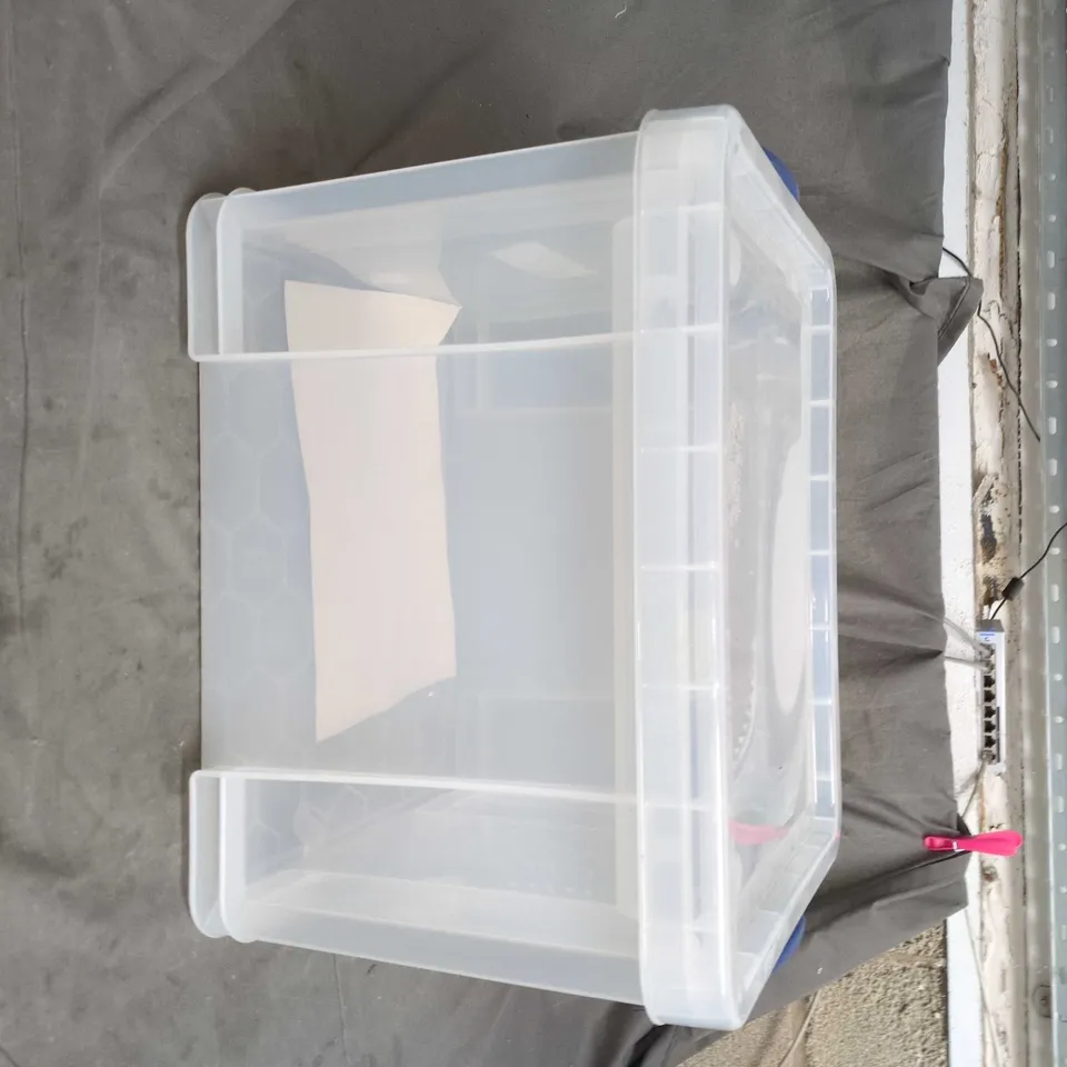 TRANSPARENT PLASTIC STORAGE BOX WITH BLUE CARRY HANDLE AND LID SZIE UNSPECIFIED .