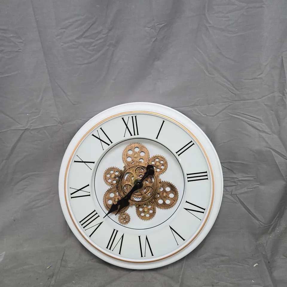 WHITE WALL CLOCK WITH ROMAN NUMERALS AND EXPOSED GEARS
