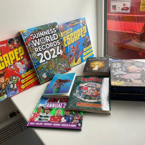 BOX OF ASSORTED ITEMS TO INCLUDE: THE LITTLE MERMAID OFFICIAL MOVIE NOVELISATION, GUINNESS WORLD RECORDS 2024, MICKEY BUSY BOOK, THE BROONS SCOTLAND HAPPY FAMILY THAT MAKESS EVERY FAMILY HAPPY ETC