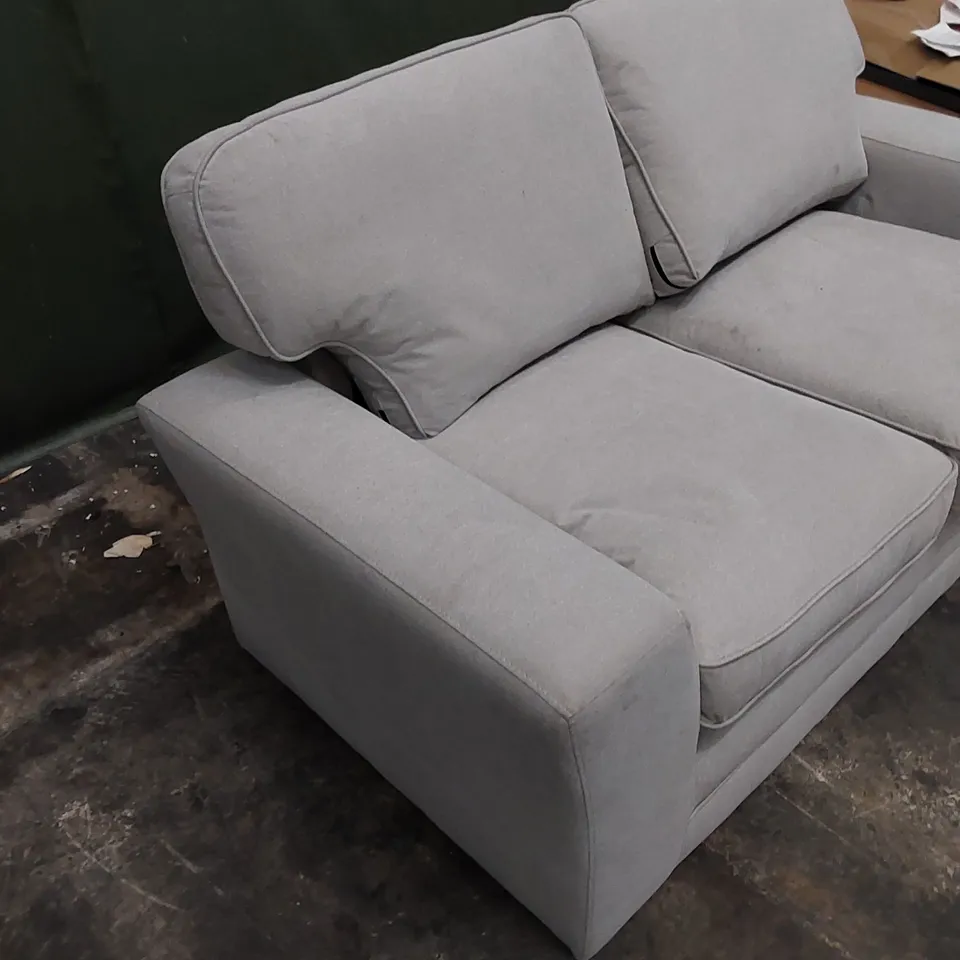 DESIGNER 2 SEATER UPHOLSTERED IN LIGHT COLOURED FABRIC 