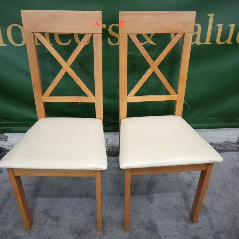 PAIR OF WOODEN DINING CHAIRS WITH CREAM FAUX LEATHER SEAT PADS 