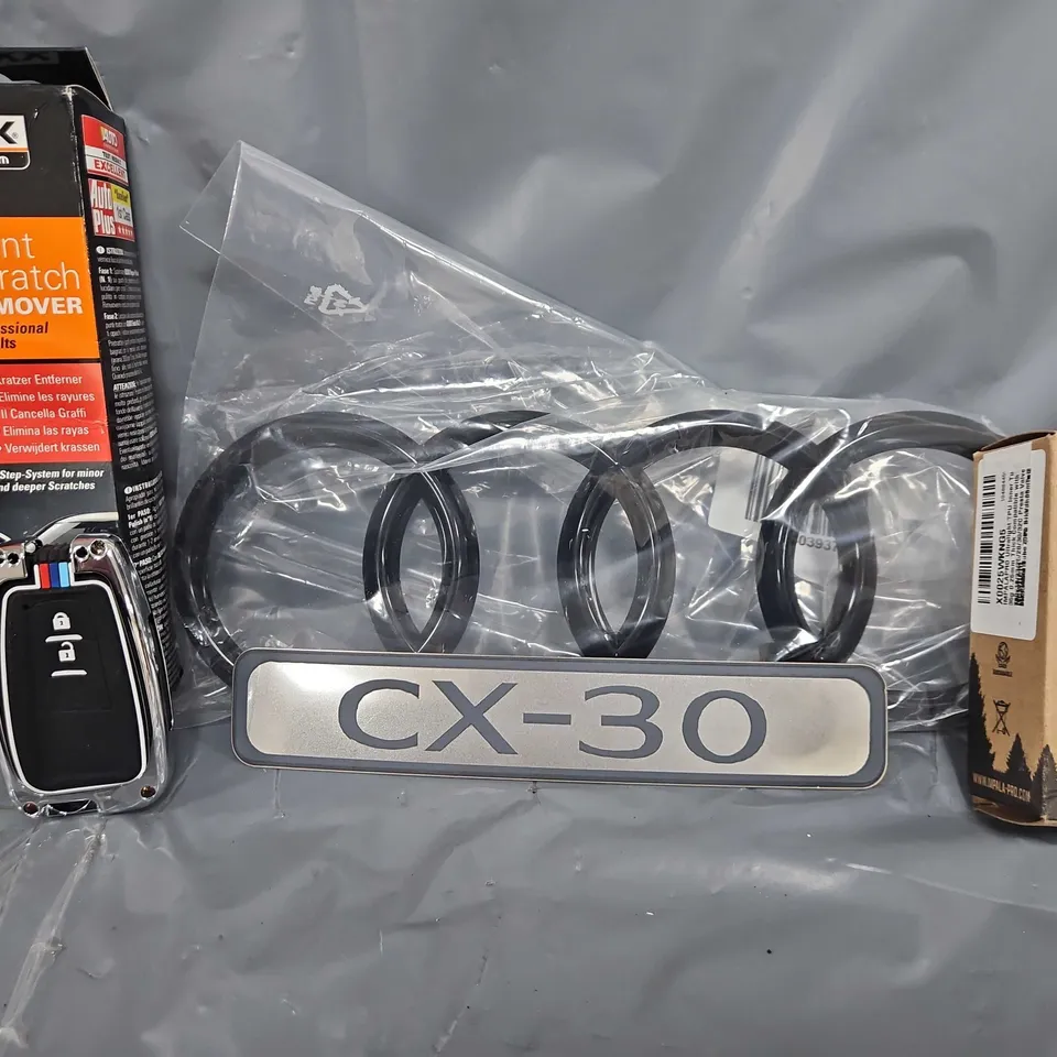TOTE OF APPROXIMATELY 9 ASSORTED VEHICLE ITEMS TO INCLUDE - BLACK AUDI BADGE  , PAINT SCRATCHED REMOVER , CX-30 BADGE ETC