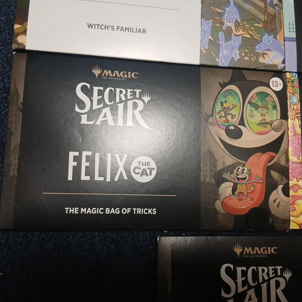 SIX ASSORTED MAGIC: THE GATHERING SECRET LAIR BOOSTERS TO INCLUDE; GARFIELD & FELIX THE CAT EACH PACK CONTAINS 5 CARDS