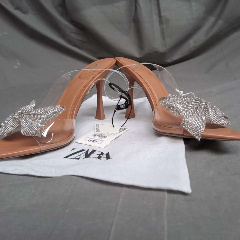 PAIR OF ZARA OPEN TOE HEELS IN CLEAR/TAN WITH SILVER BOW DETAIL SIZE 5