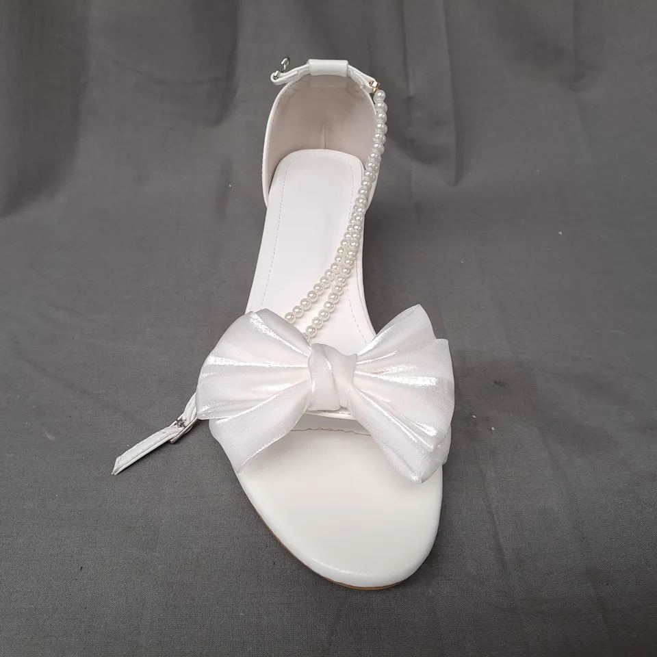 BOXED PAIR OF DESIGNER OPEN TOE BLOCK HEEL BRIDAL STYLE SANDALS IN WHITE W. BOW DETAIL AND PEARL EFFECT STRAP EU SIZE 44