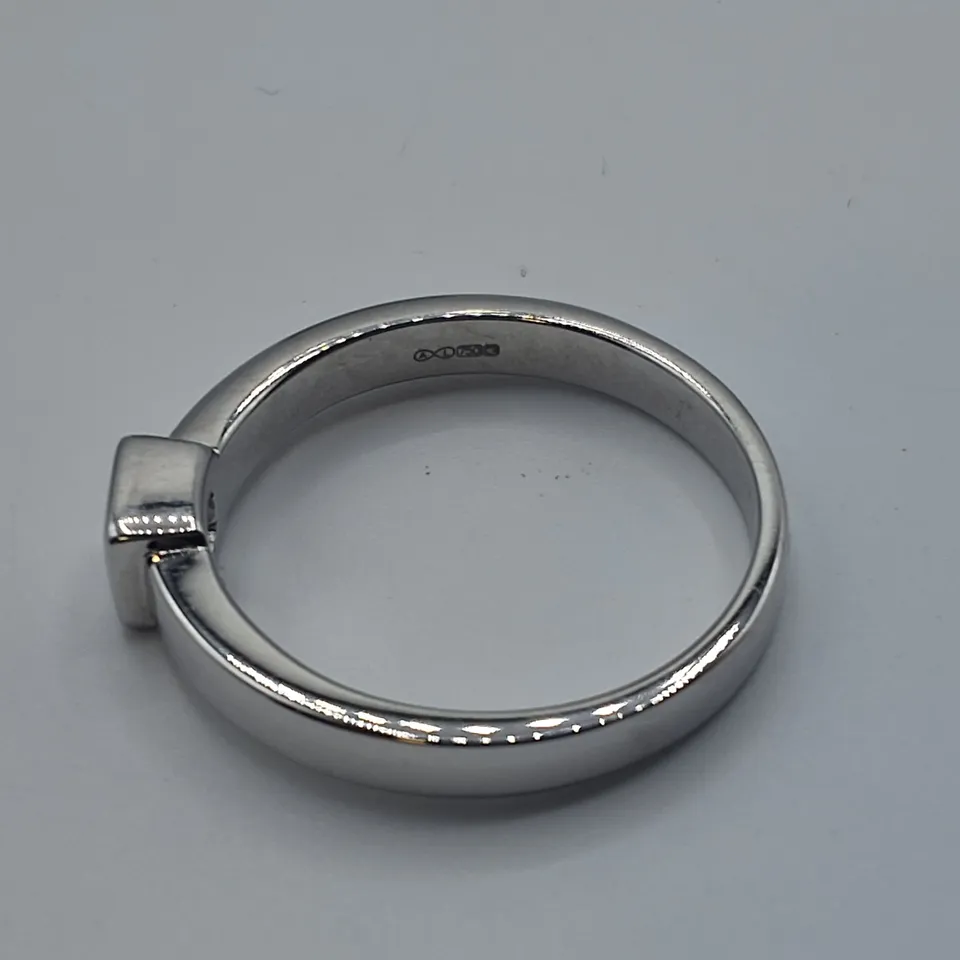 18CT WHITE GOLD SOLITAIRE RING SET WITH A NATURAL RUB OVER DIAMOND