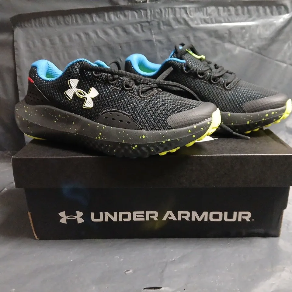BOXED PAIR OF UNDER ARMOUR BGS SURGE 4 TRAINERS IN BLACK/MULTI SIZE UK 4