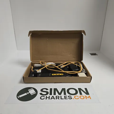 BLACK BT ELECTRONIC NETWORKING DEVICE IN BOX WITH YELLOW CABLES