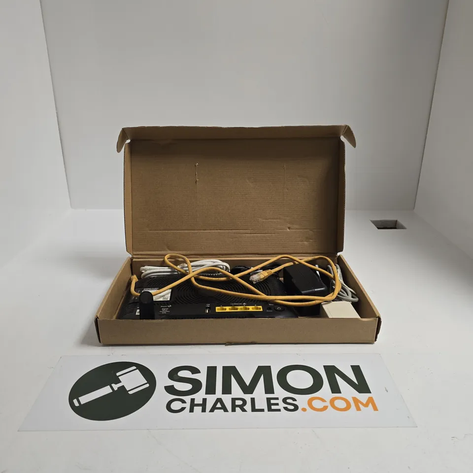 BLACK BT ELECTRONIC NETWORKING DEVICE IN BOX WITH YELLOW CABLES