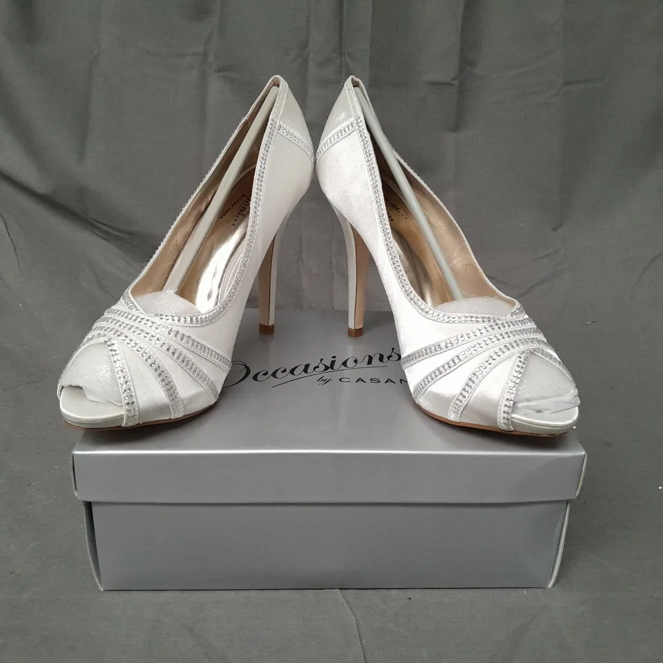 BOX OF APPROXIMATELY 10 BOXED PAIRS OF OCCASIONS BY CASANDRA PEEP TOE HIGH HEEL SHOES IN IVORY SATIN W. JEWEL EFFECT - VARIOUS SIZES