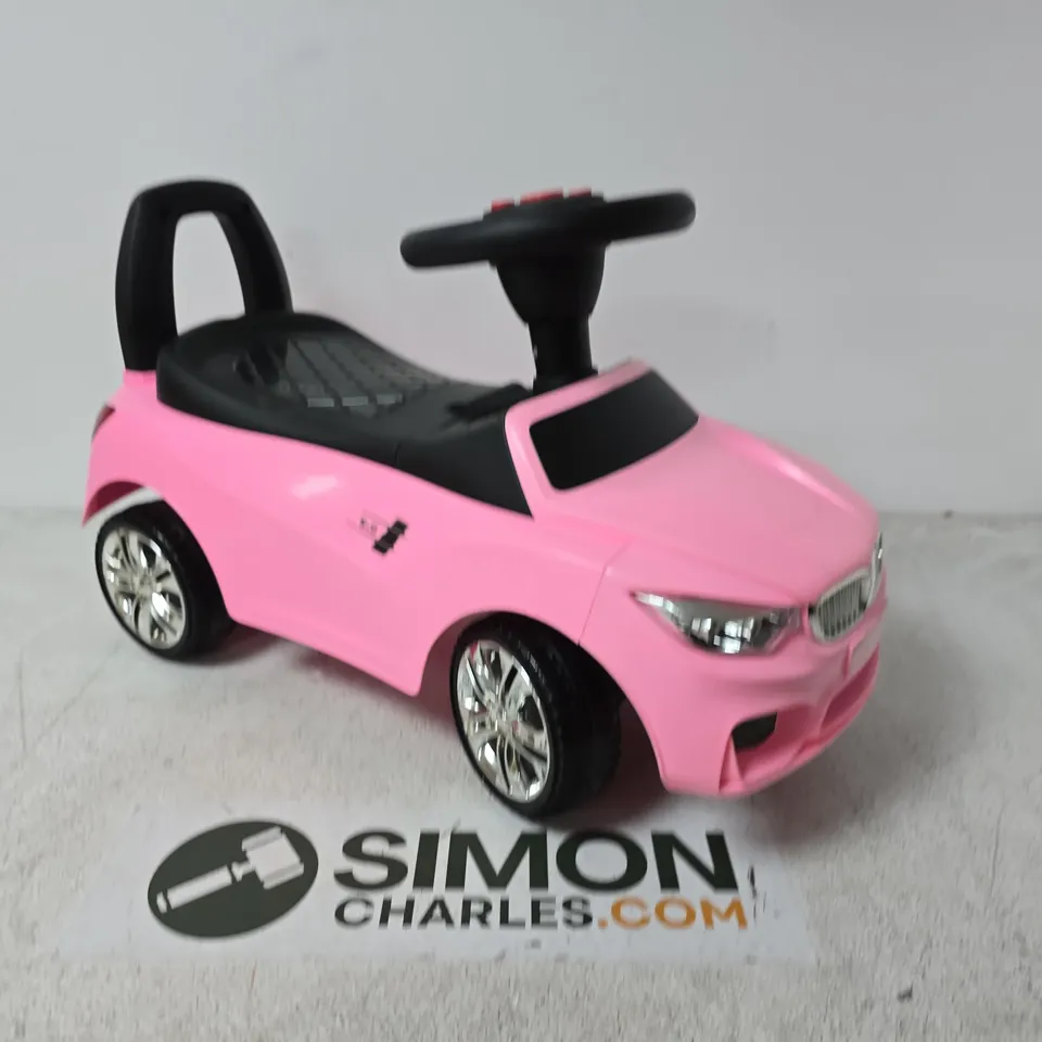 PINK CHILDREN'S RIDE-ON TOY CAR WITH BLACK SEAT AND CHROME WHEELS