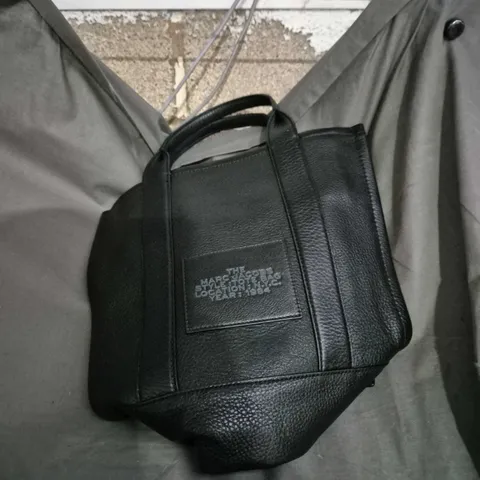 The Marc Jacobs Tote Bag – Black Leather with Front Patch Reading 'THE MARC JACOBS STYLE TOTTE BAG LOCATION NYC YEAR 1984'